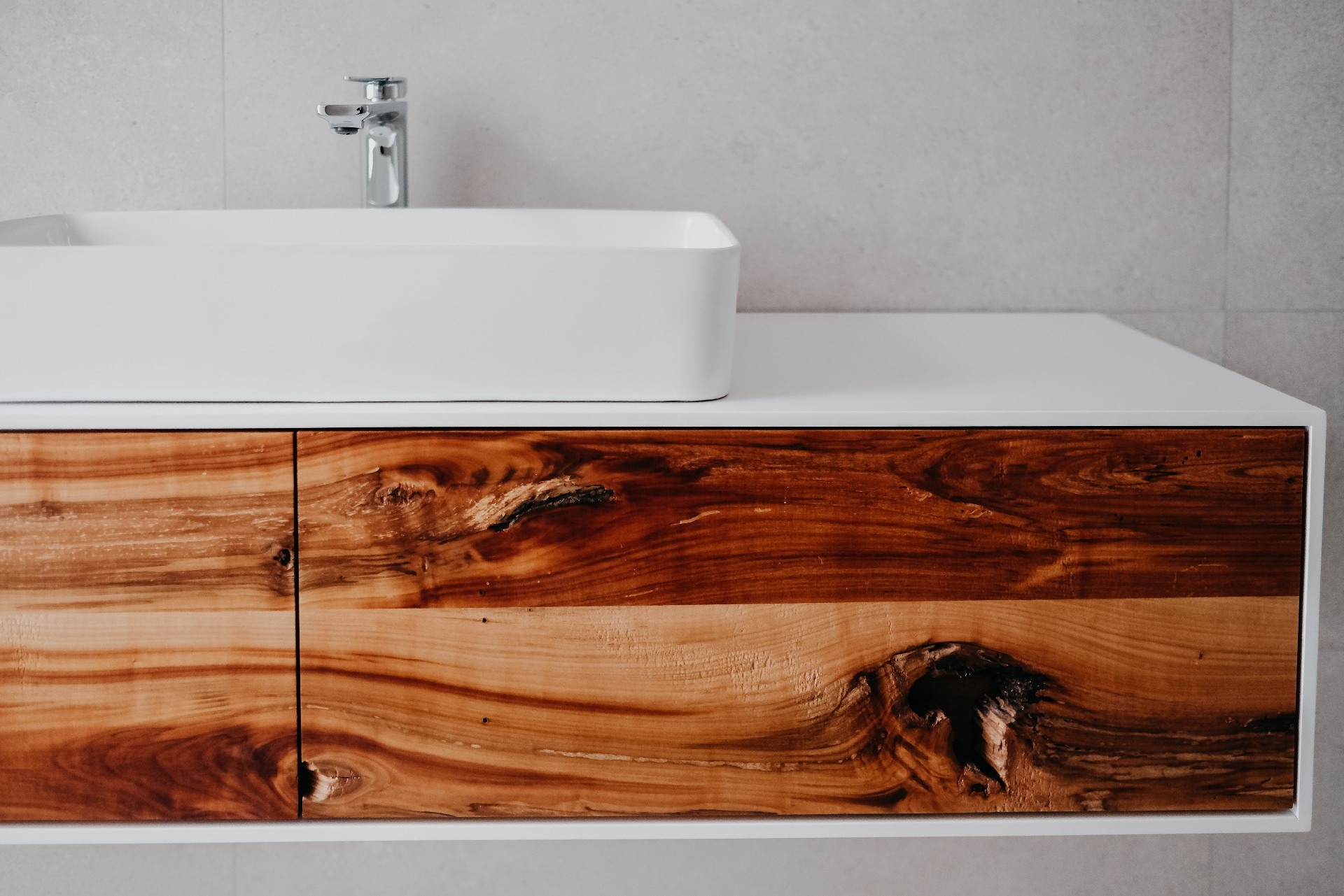 A beautiful shot of lavatory on a wooden cabinet in a modern bathroom